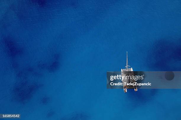 sailing ship on an ocean of blue - catamaran stock pictures, royalty-free photos & images
