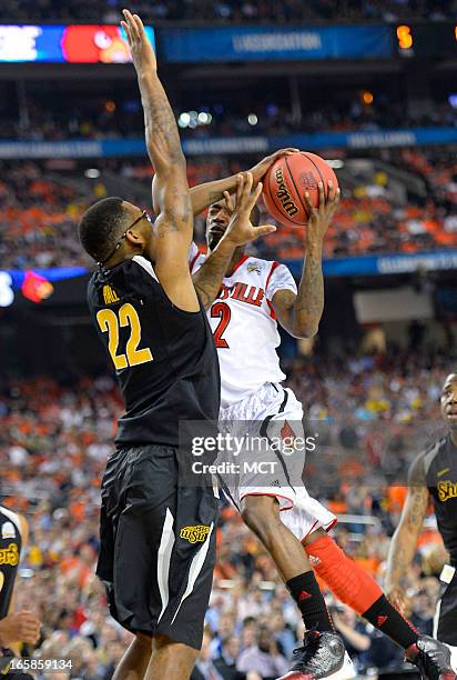 Louisville guard Russ Smith shoots against Carl Hall of the Wichita State Shockers in the first half of a semi-final matchup in the NCAA Men's...