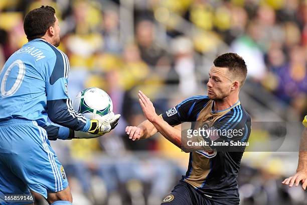Goalkeeper Andy Gruenebaum of the Columbus Crew gains control of the ball as Jack McInerney of Philadelphia Union runs by in the first half on April...