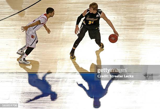 Ron Baker of the Wichita State Shockers runs the offense in the first half against Peyton Siva of the Louisville Cardinals during the 2013 NCAA Men's...