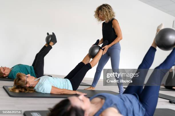 pilates studio gym: exercises class on mat with ball - sfeer stockfoto's en -beelden