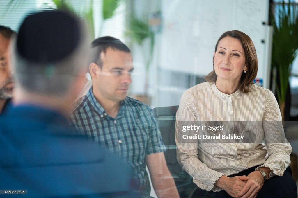 Mature Jewish market agent leading group training session.