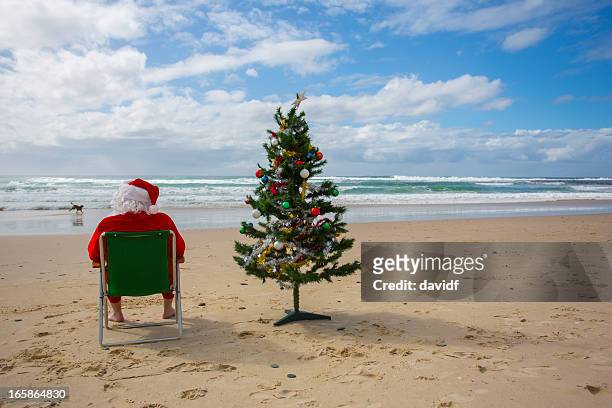 santa claus relaxing at the beach with a christmas tree - christmas australia stock pictures, royalty-free photos & images