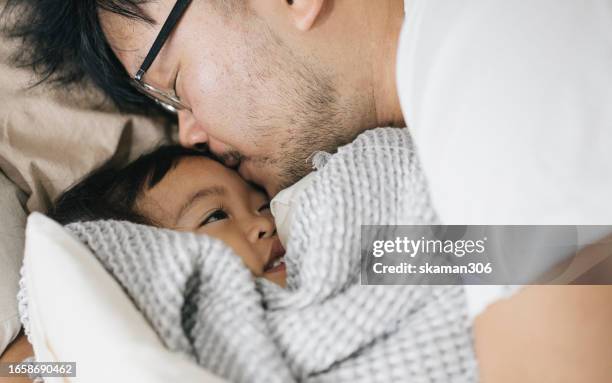 close-up shot of dad sharing a kiss with his toddler duaghter - genuine fatherly love and happiness - couple portrait soft stock-fotos und bilder