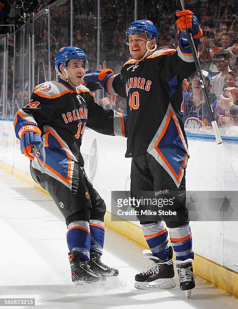 Thomas Hickey of the New York Islanders congratulates teammate Michael Grabner on his first period goal during the game against the Tampa Bay...