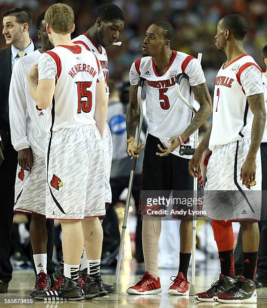 Injured guard Kevin Ware of the Louisville Cardinals talks with teammates Tim Henderson, Montrezl Harrell and Russ Smith during a timeout in the...