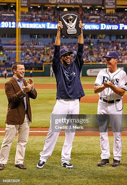 Pitcher David Price of the Tampa Bay Rays celebrates his Cy Young award as General Manager Andrew Friedman and pitching coach Jim Hickey look on just...