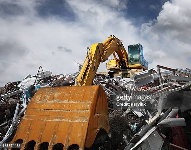 excavator working at garbage dump - junkyard stockfoto's en -beelden