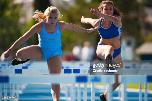 weibliche athleten im rennen hürde - hurdling track event stock-fotos und bilder