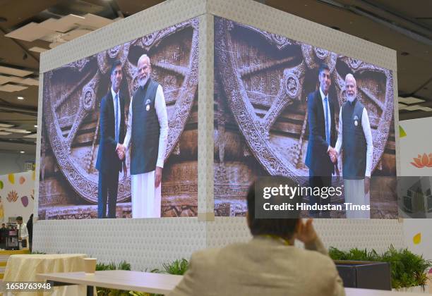 Media personnel inside International Media Centre watching live telecast of Prime Minister Narendra Modi welcome United Kingdom Prime Minister Rishi...