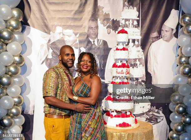 Cedric Gay and Assata Akil Gay, both of Mexico, pose with a six-tiered cake that was inspired by Elvis and Priscilla Presley's 1967 wedding cake,...