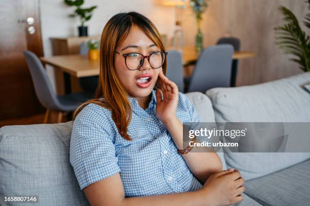 young woman having toothache at home - toothache stock pictures, royalty-free photos & images