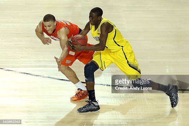 Caris LeVert of the Michigan Wolverines attempts to control the ball in the second half against Brandon Triche of the Syracuse Orange during the 2013...