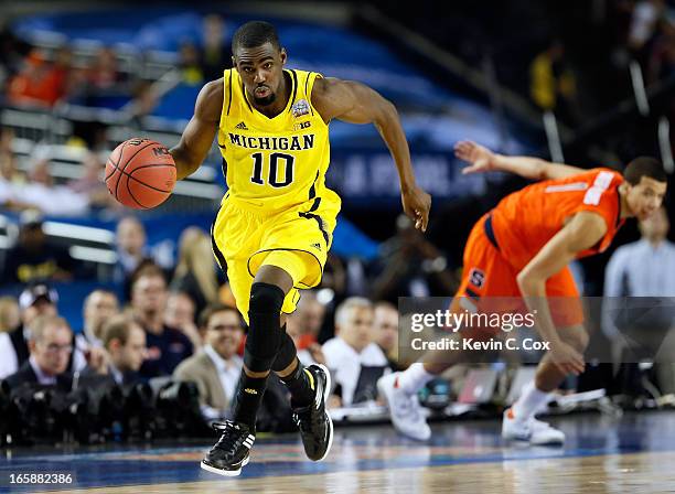 Tim Hardaway Jr. #10 of the Michigan Wolverines pushes the ball up court in the second half against Michael Carter-Williams of the Syracuse Orange...