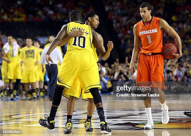 Tim Hardaway Jr. #10 and Trey Burke of the Michigan Wolverines react in the second half against Michael Carter-Williams of the Syracuse Orange during...