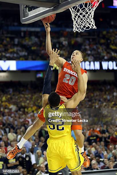 Brandon Triche of the Syracuse Orange is called for a charging foul in the final minute of the second half against Jordan Morgan of the Michigan...