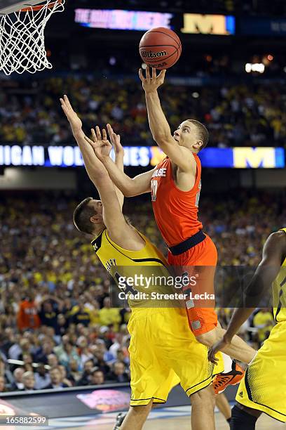Brandon Triche of the Syracuse Orange drives for a shot attempt in the second half against Mitch McGary of the Michigan Wolverines during the 2013...