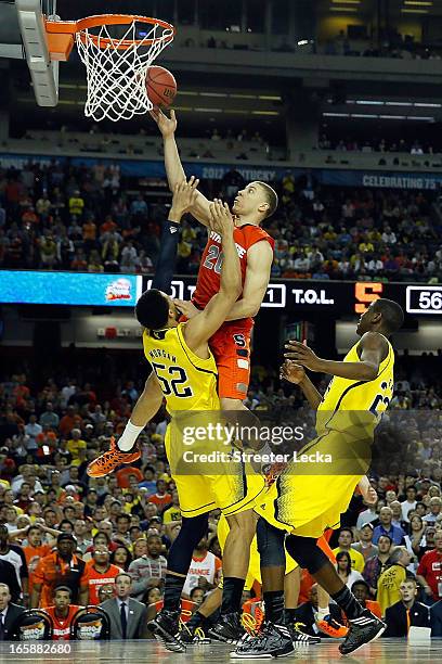 Brandon Triche of the Syracuse Orange is called for a charging foul in the final minute of the second half against Jordan Morgan of the Michigan...