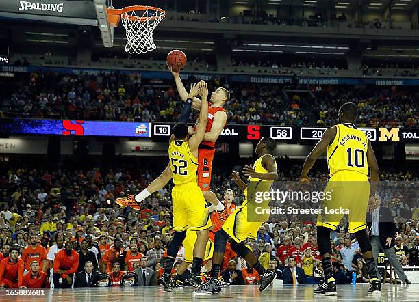 Brandon Triche of the Syracuse Orange is called for a charging foul in the final minute of the second half against Jordan Morgan of the Michigan...