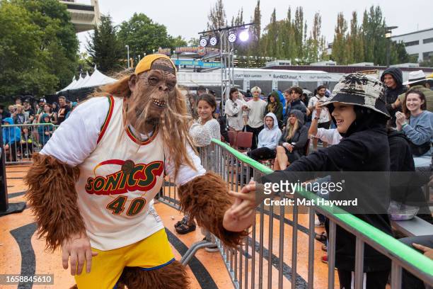 Seattle Supersonics basketball maskot Squatch high fives a fan at Bumbermania professional wrestling during the 50th Anniversary of the Bumbershoot...