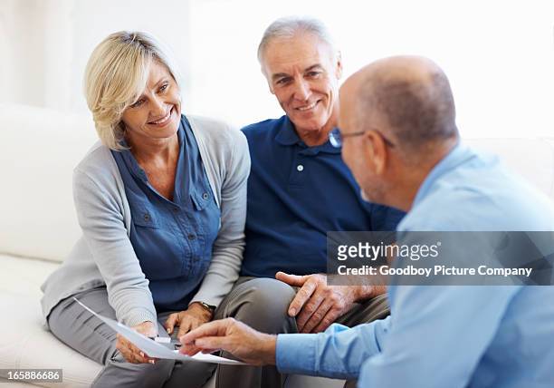 couple smiling and listening to financial planner - business couple showing stockfoto's en -beelden