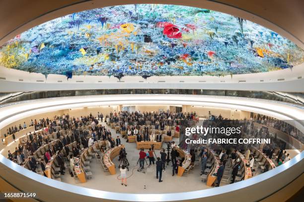 Delegates stand for a minute of silence following the deadly 6.8-magnitude September 8 earthquake, in central Morocco, at the opening of the 54th UN...