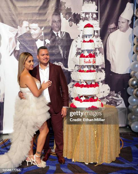 Joanna Perez and Sam Perez, both of Nevada, pose with a six-tiered cake that was inspired by Elvis and Priscilla Presley's 1967 wedding cake,...