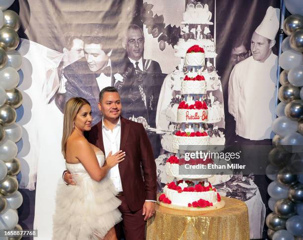 Joanna Perez and Sam Perez, both of Nevada, pose with a six-tiered cake that was inspired by Elvis and Priscilla Presley's 1967 wedding cake,...