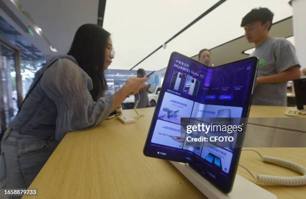 Customers experience Huawei's latest foldable screen phone Mate X5 at a Huawei store in Hangzhou, East China's Zhejiang province, Sept 11, 2023. A...