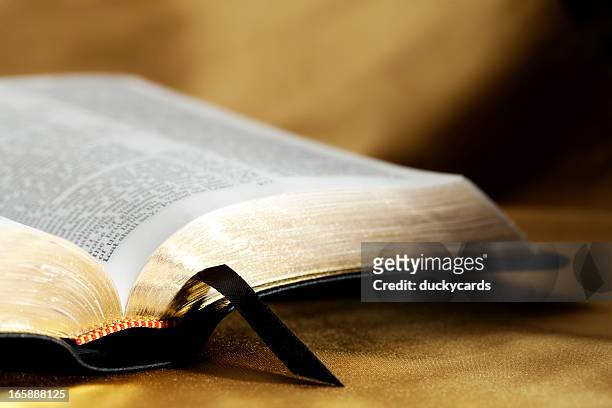 öffnen sie bibel auf gold hintergrund - religion stock-fotos und bilder