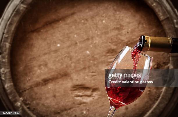 red wine  poured into glas - cellar stockfoto's en -beelden