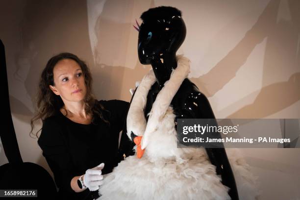 Elise Foster Vander Els, Head of Exhibitions at the Design Museum looks at the swan dress, worn by Bjork at the 2001 Oscars, on show during a...