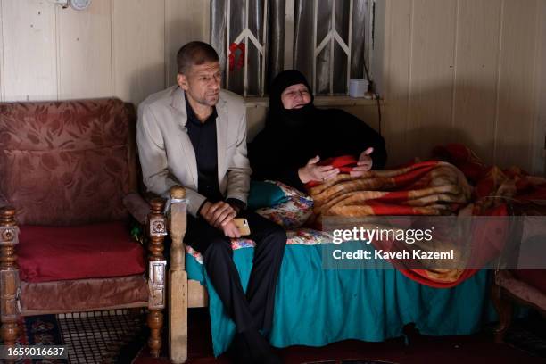 Mother and brother of a Shiite Iraqi soldier killed by ISIS and hanged from a bridge seen in his family home in Sadr City on March 18, 2023 in...