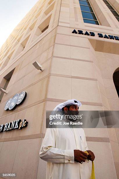 Business man walks past the Arab Bank November 25,2002 in Manama, Bahrain. With war in Iraq on the horizon, the Middle East is preparing for some...