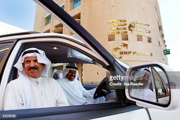 Business men sit in front of the United Gulf Bank Tower November 25,2002 in Manama, Bahrain. With war in Iraq on the horizon, the Middle East is...