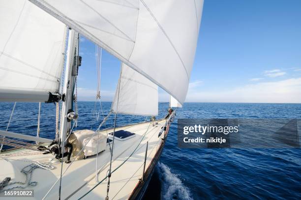 navegar hacia el horizonte en un día soleado - barco-de-vela fotografías e imágenes de stock