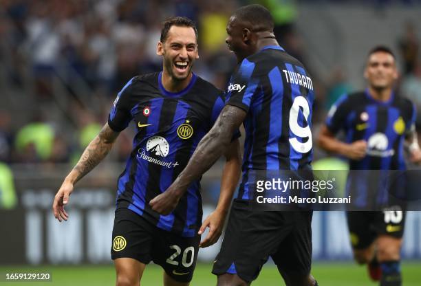 Hakan Calhanoglu of FC Internazionale celebrates with his team-mate Marcus Thuram after scoring the team's third goal during the Serie A TIM match...
