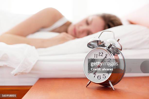 alarm clock on bedside table - awake day stockfoto's en -beelden