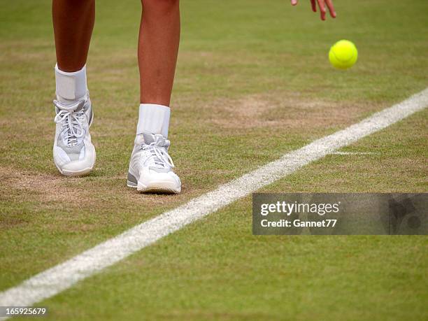 close-up on a tennis player's feet as they prepare to serve - bouncing tennis ball stock pictures, royalty-free photos & images