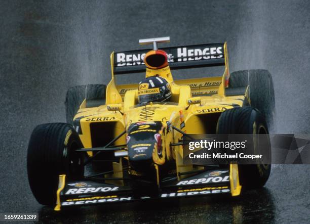 Damon Hill from Great Britain drives the Benson & Hedges Jordan Grand Prix Jordan 198 Mugen Honda V10 in the rain during the Formula One Belgian...