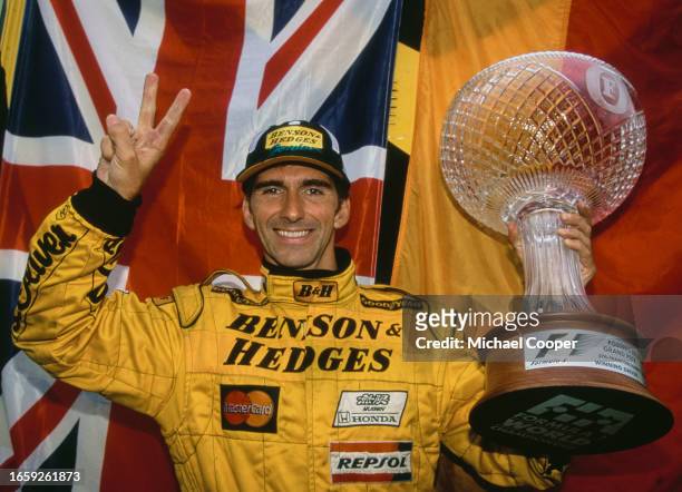 Damon Hill from Great Britain, driver of the Benson & Hedges Jordan Grand Prix Jordan 198 Mugen Honda V10 gives the victory v sign and celebrates...