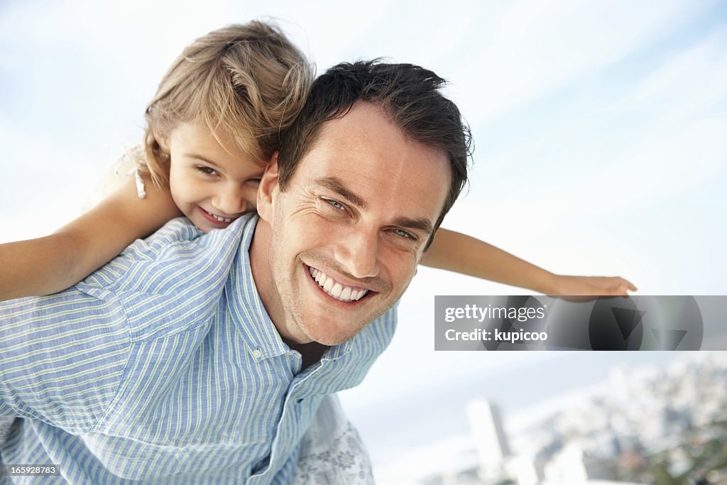 Girl enjoying piggyback ride with father