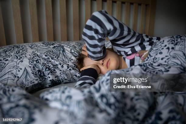 child lying in bed, rubbing both eyes and waking up in the morning. - alpha female stock pictures, royalty-free photos & images
