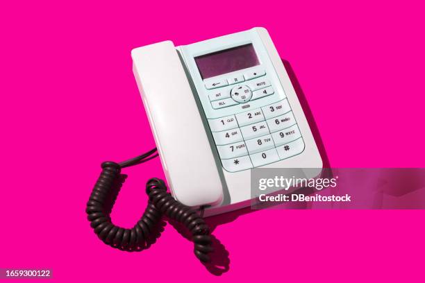 white retro telephones, with cord, on a pink background. concept of old, telephony, landline, talk, distance, listen, switchboard and customer service. - telephone switchboard stock-fotos und bilder