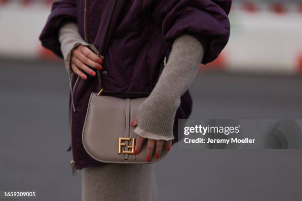 Sonia Lyson seen wearing Fendi beige knit pullover, matching Fendi beige knit long skirt, The Frankie Shop purple oversized bomber jacket, on...