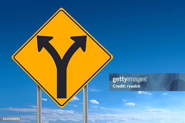 choice or division ahead road sign post on blue sky - street sign stockfoto's en -beelden