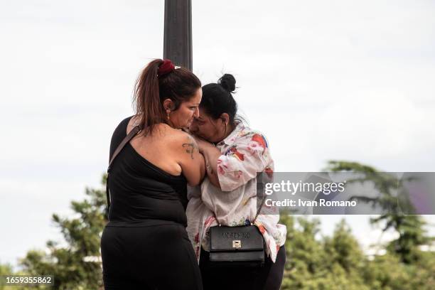 Two women clinging to a lamppost suspended about 20 meters high, threaten to jump into the void during a protest against the decision to abolish the...