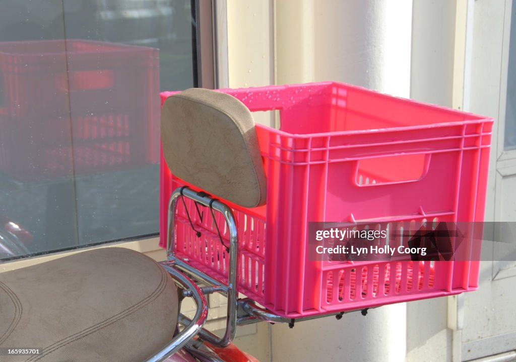 Pink plastic crate on scooter