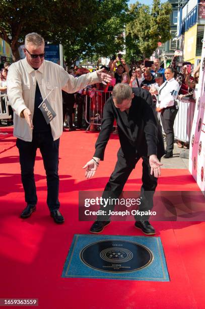 Graham McPherson aka Suggs of Madness poses with Ali Campbell of UB40 next to UB40's Music Walk of Fame plaque at the unveiling of The Music Walk Of...