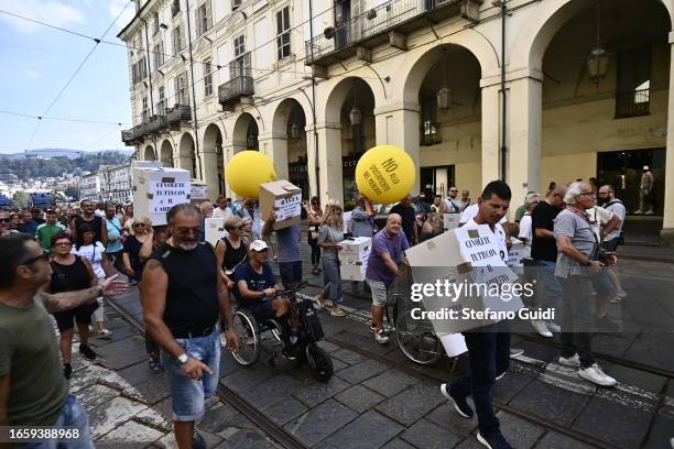 People hold placards protest during the strike by vendors in Turin's general markets against ever higher taxes on September 4, 2023 in Turin, Italy.